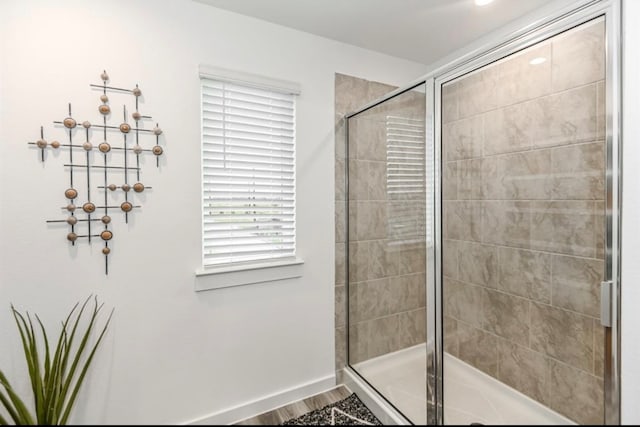 bathroom with hardwood / wood-style flooring and a shower with shower door