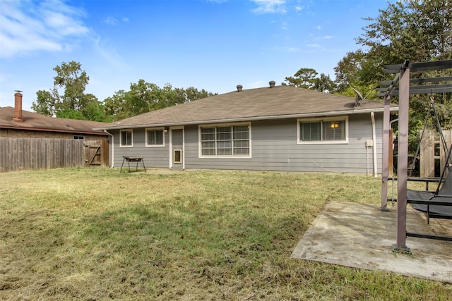 rear view of property featuring a patio and a yard