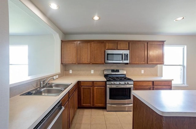 kitchen featuring light tile patterned floors, appliances with stainless steel finishes, tasteful backsplash, and sink