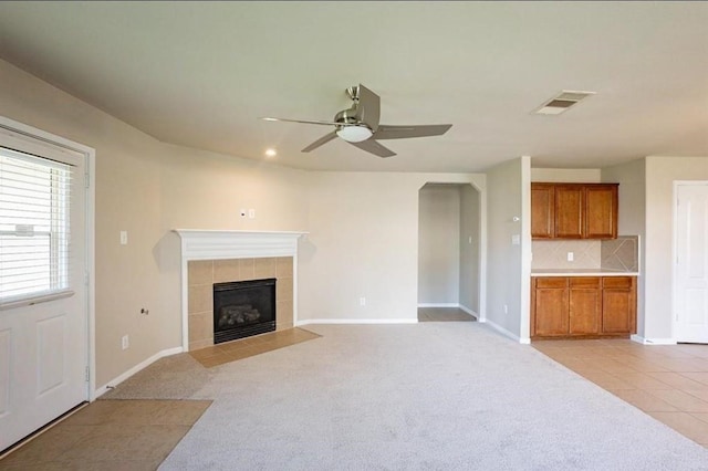 carpeted living room with ceiling fan and a fireplace