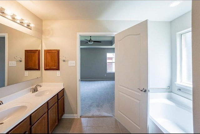 bathroom with ceiling fan, vanity, a bathtub, and tile patterned floors