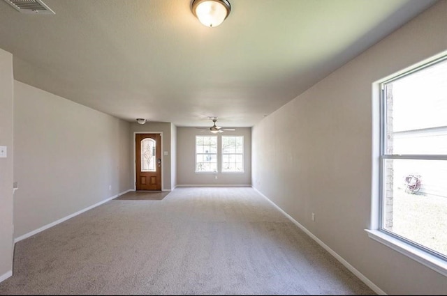 unfurnished living room featuring ceiling fan and light colored carpet