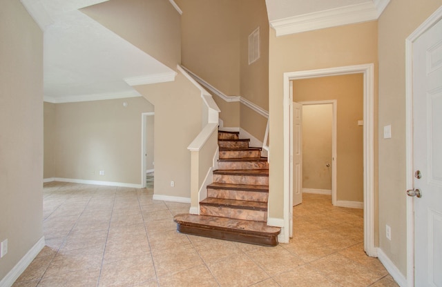 stairs featuring tile patterned floors and crown molding