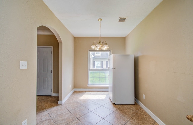 doorway to outside with an inviting chandelier and light tile patterned flooring