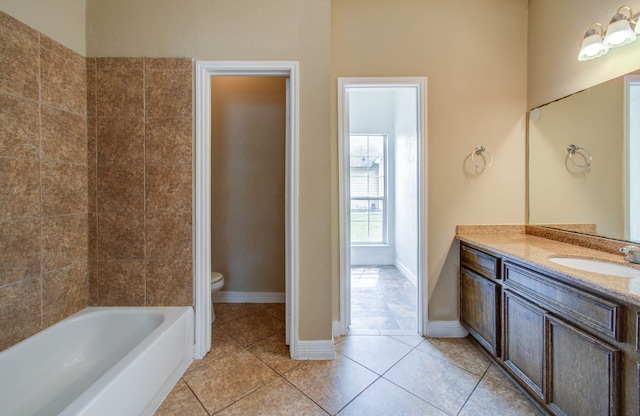 bathroom featuring vanity, tile patterned floors, toilet, and a tub