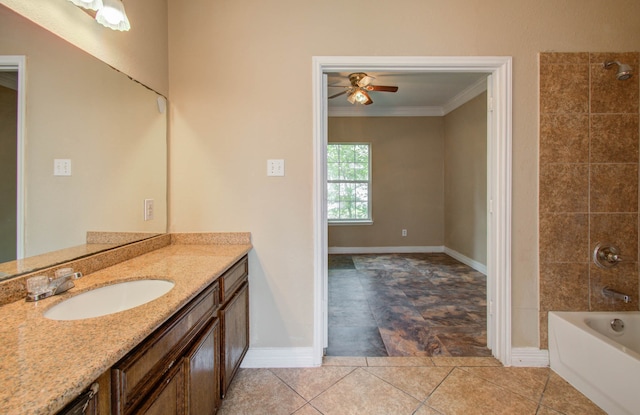 bathroom with tile patterned flooring, tiled shower / bath combo, ornamental molding, ceiling fan, and vanity