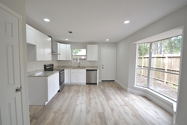 kitchen featuring white cabinets, stainless steel appliances, and a healthy amount of sunlight