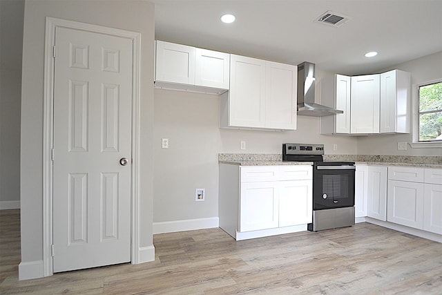 kitchen featuring white cabinets, wall chimney exhaust hood, light wood-type flooring, and stainless steel electric range