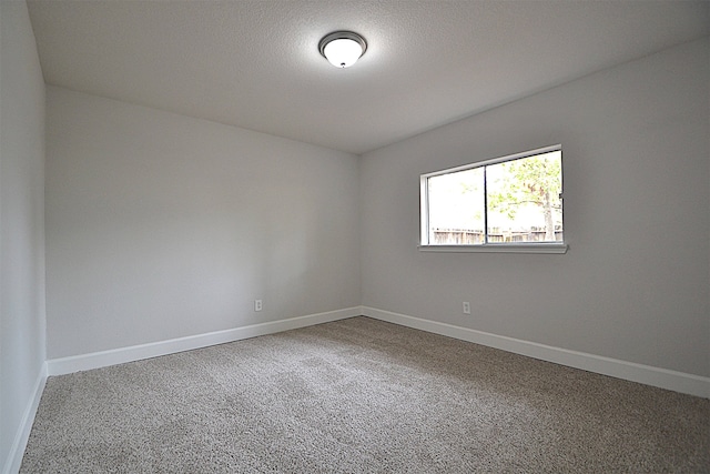 carpeted spare room featuring a textured ceiling