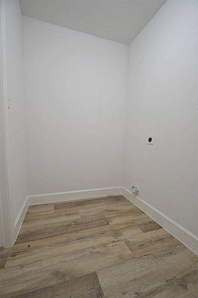 laundry area with hookup for an electric dryer and hardwood / wood-style flooring