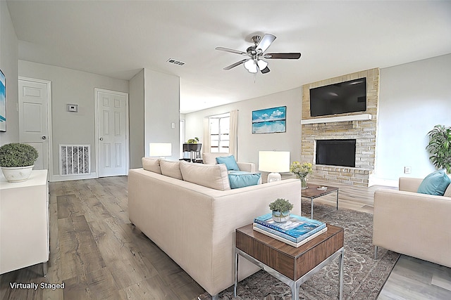 living room featuring a fireplace, hardwood / wood-style floors, and ceiling fan