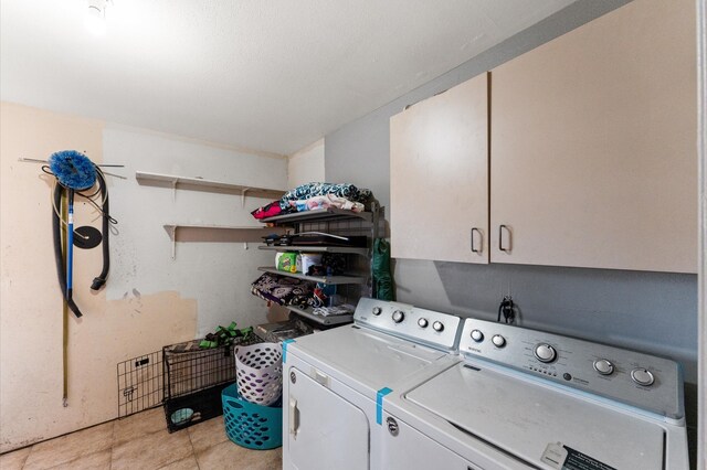 washroom with washer and clothes dryer, cabinets, and light tile patterned floors