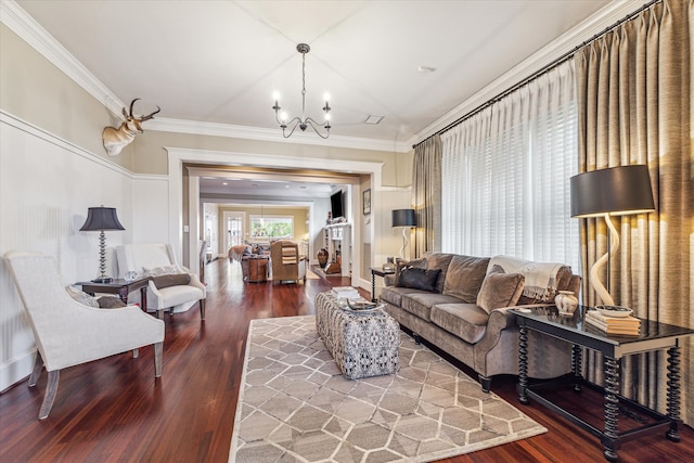 living room with ornamental molding, hardwood / wood-style floors, and a chandelier