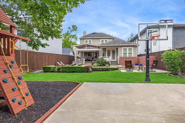 rear view of house featuring a patio, an outdoor living space with a fire pit, and a yard