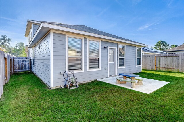 back of property with a yard and a patio