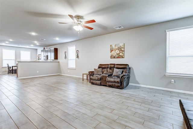 living room with light wood-type flooring and ceiling fan