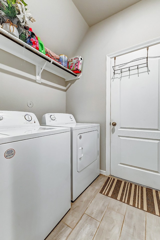 clothes washing area featuring light wood-type flooring and separate washer and dryer