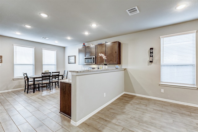 kitchen with light stone counters and light hardwood / wood-style floors