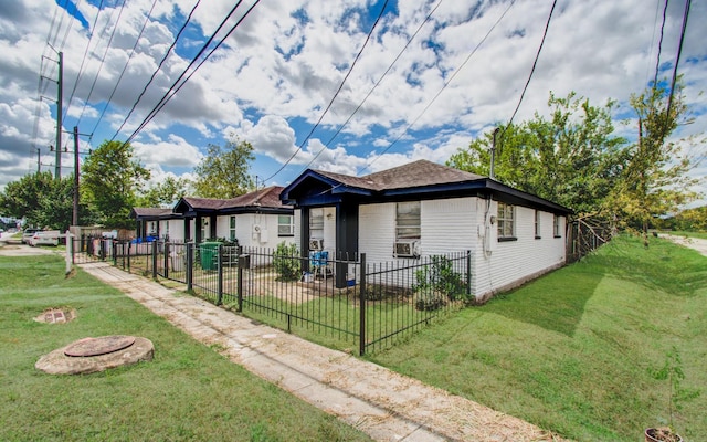view of home's exterior with a lawn, an outdoor fire pit, and a fenced front yard