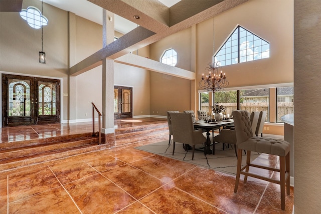 dining space with a notable chandelier, tile patterned flooring, a towering ceiling, and plenty of natural light