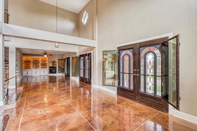 foyer featuring tile patterned flooring, a high ceiling, and ceiling fan