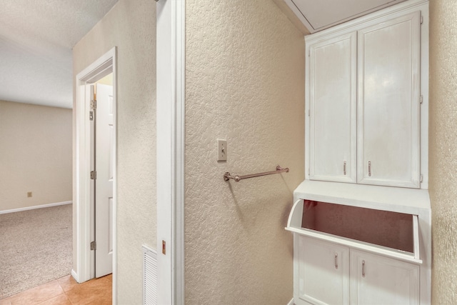 bathroom featuring a textured ceiling and tile patterned flooring