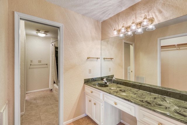 bathroom with vanity, shower / bathing tub combination, tile patterned floors, and a textured ceiling