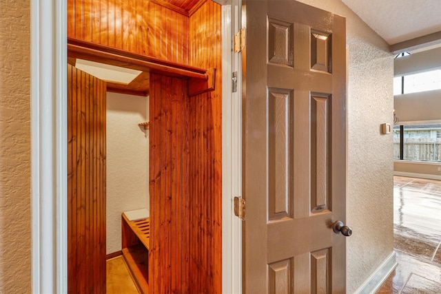 bathroom with a textured ceiling and wooden walls