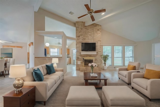 tiled living room with a fireplace, ceiling fan, and high vaulted ceiling