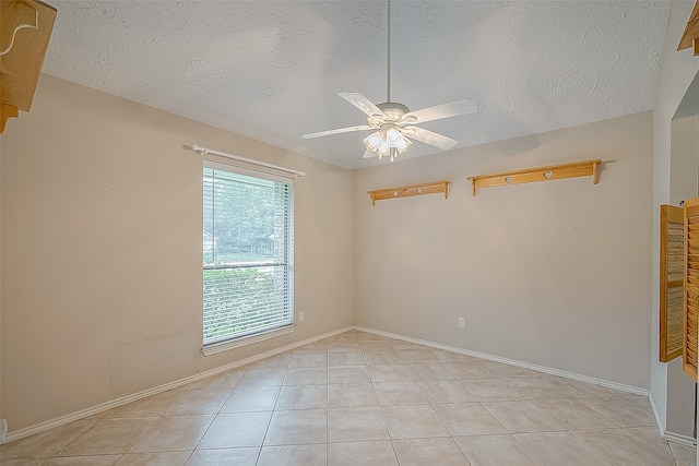 unfurnished room with ceiling fan, a textured ceiling, and light tile patterned floors