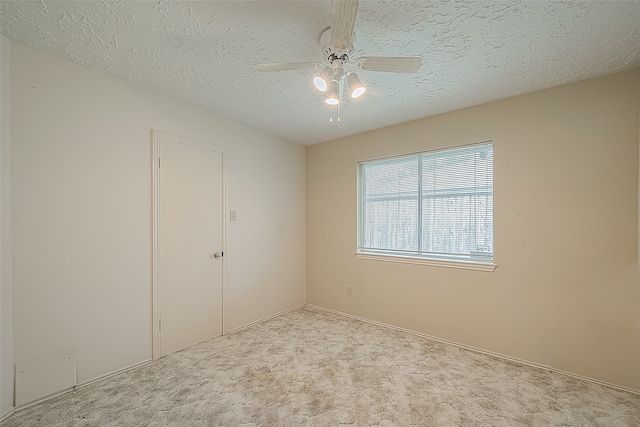 carpeted spare room featuring a textured ceiling and ceiling fan