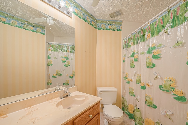 bathroom featuring vanity, a textured ceiling, walk in shower, ceiling fan, and toilet