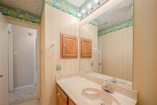 bathroom with a textured ceiling, vanity, and tile patterned floors