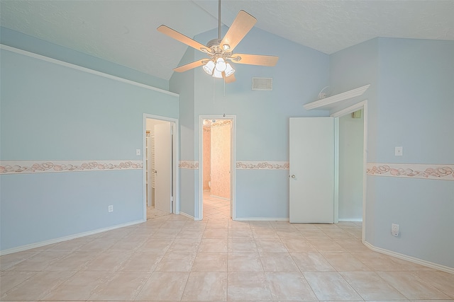 empty room with tile walls, a textured ceiling, light tile patterned flooring, high vaulted ceiling, and ceiling fan