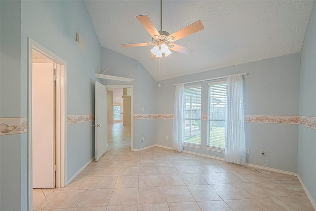 tiled empty room with ceiling fan, a textured ceiling, and lofted ceiling