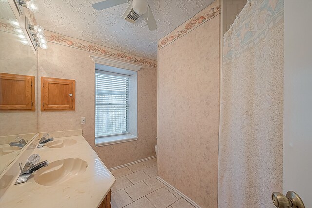 bathroom featuring a textured ceiling, tile patterned floors, ceiling fan, vanity, and toilet