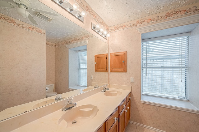 bathroom with vanity, tile patterned flooring, toilet, and a textured ceiling