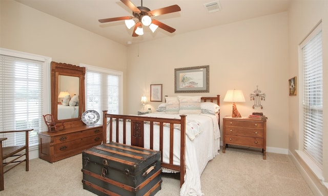 bedroom with light carpet, multiple windows, and ceiling fan