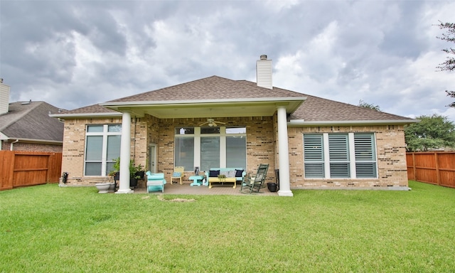 back of property with ceiling fan, a lawn, and a patio area