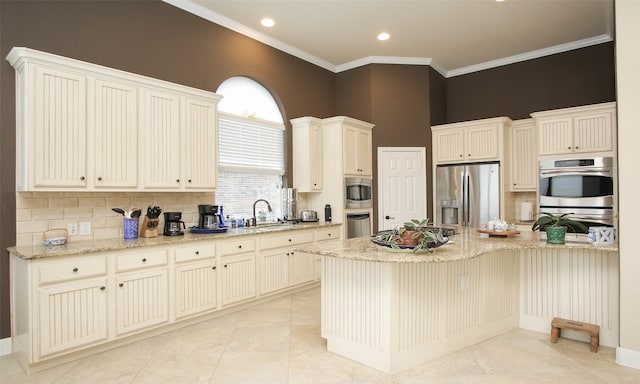 kitchen featuring light stone countertops, decorative backsplash, sink, ornamental molding, and appliances with stainless steel finishes