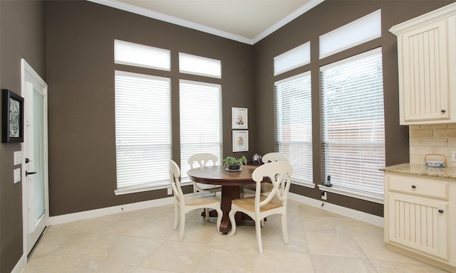 dining space featuring light tile patterned flooring and ornamental molding