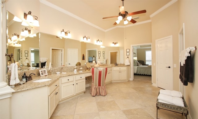 bathroom with tile patterned flooring, ceiling fan, crown molding, a towering ceiling, and vanity