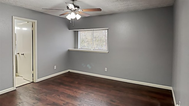 spare room with a textured ceiling, dark hardwood / wood-style floors, and ceiling fan