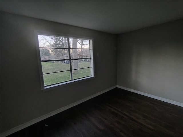 unfurnished room with dark hardwood / wood-style flooring