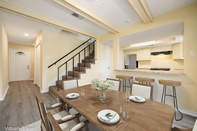 dining area with beamed ceiling and dark hardwood / wood-style flooring