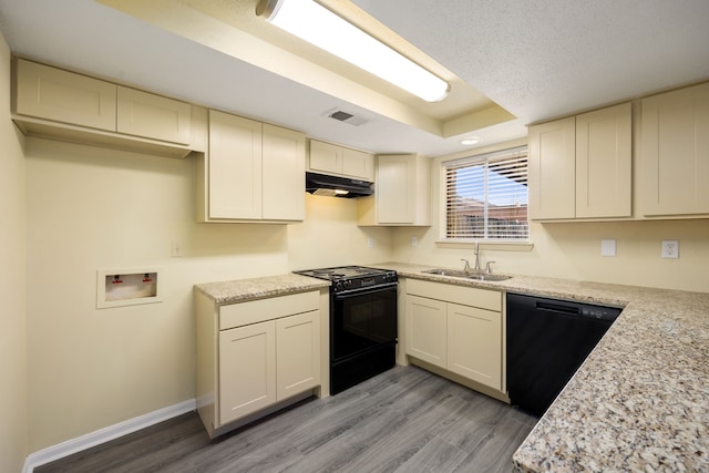 kitchen with light wood-type flooring, black appliances, sink, and light stone counters