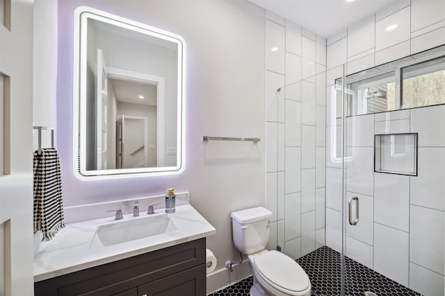 bathroom with vanity, toilet, and a shower with door