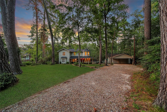 view of front of property with a yard, an outdoor structure, and a garage