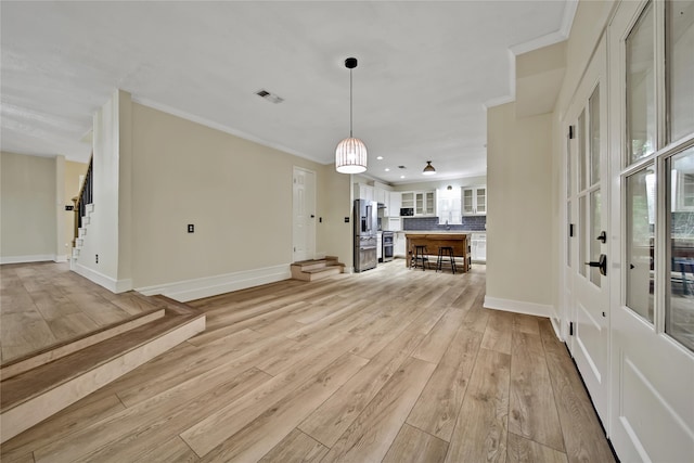 entrance foyer featuring light hardwood / wood-style flooring and crown molding