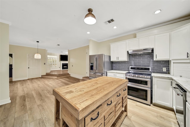 kitchen with stainless steel appliances, white cabinetry, and decorative light fixtures